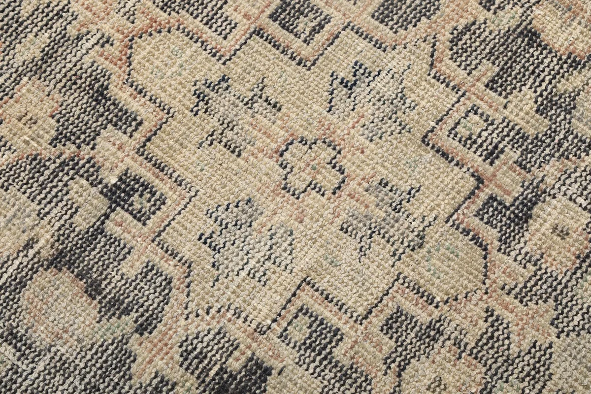 Extreme close-up of the hand-knotted wool pile, showing the texture and low pile height.