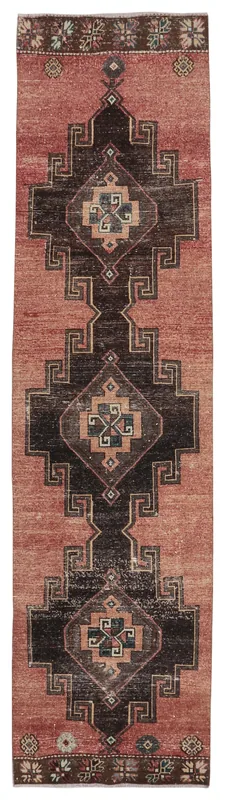 Full overhead view of the rust and charcoal geometric vintage runner rug on a white background