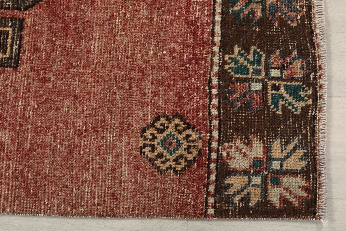 Detailed view of the rust field and part of the charcoal border with small floral elements