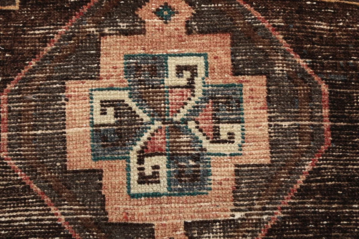Extreme close-up showing the hand-knotted wool pile texture and intricate details of a medallion