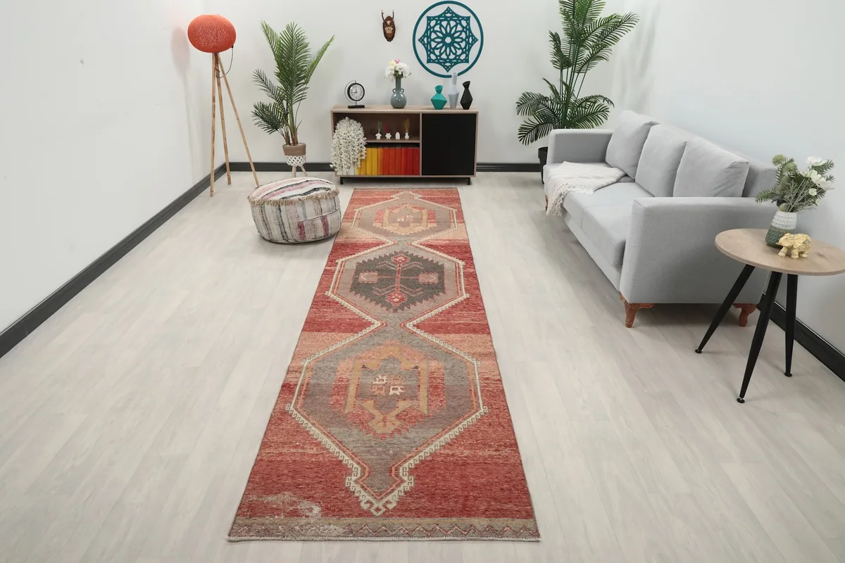 Vintage Anatolian runner rug displayed in a modern living room setting, showing its full length