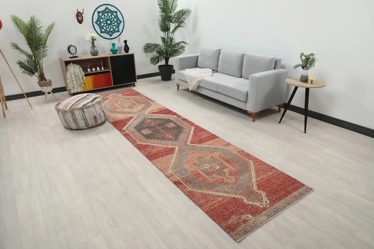Angle view of the rust and gray geometric runner rug in a room with a sofa and decor