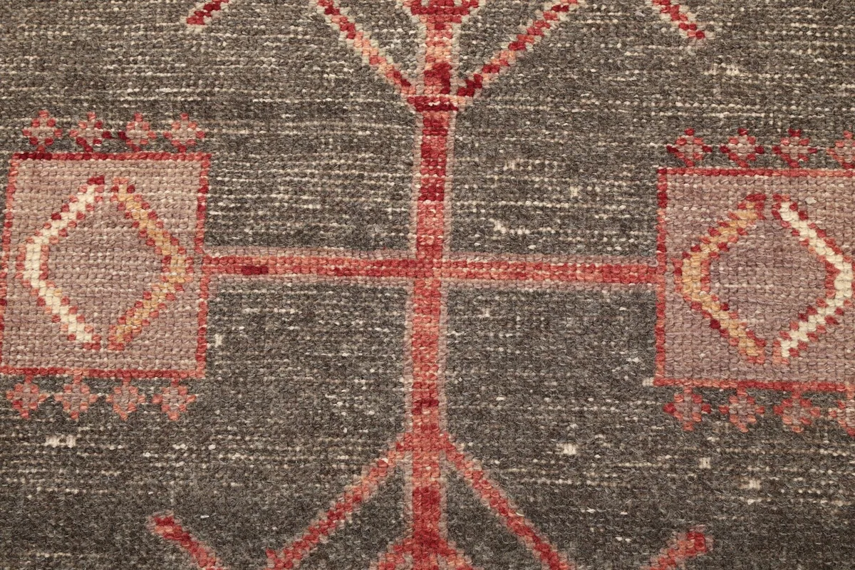Extreme close-up of the central medallion's tribal motifs and wool pile texture