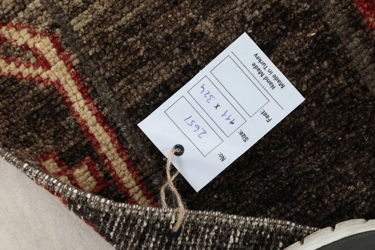 Close-up of the rug's tag, displaying its size in centimeters and feet, and origin