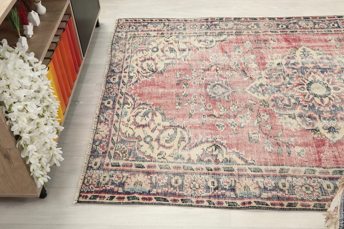 Angled view of the rug's surface, highlighting wear and color variations