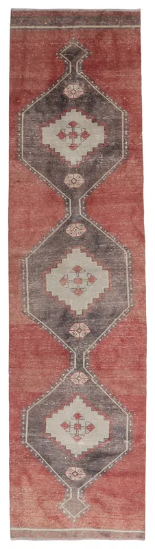 Full overhead view of the vintage rust and charcoal geometric Anatolian runner rug on a white background.