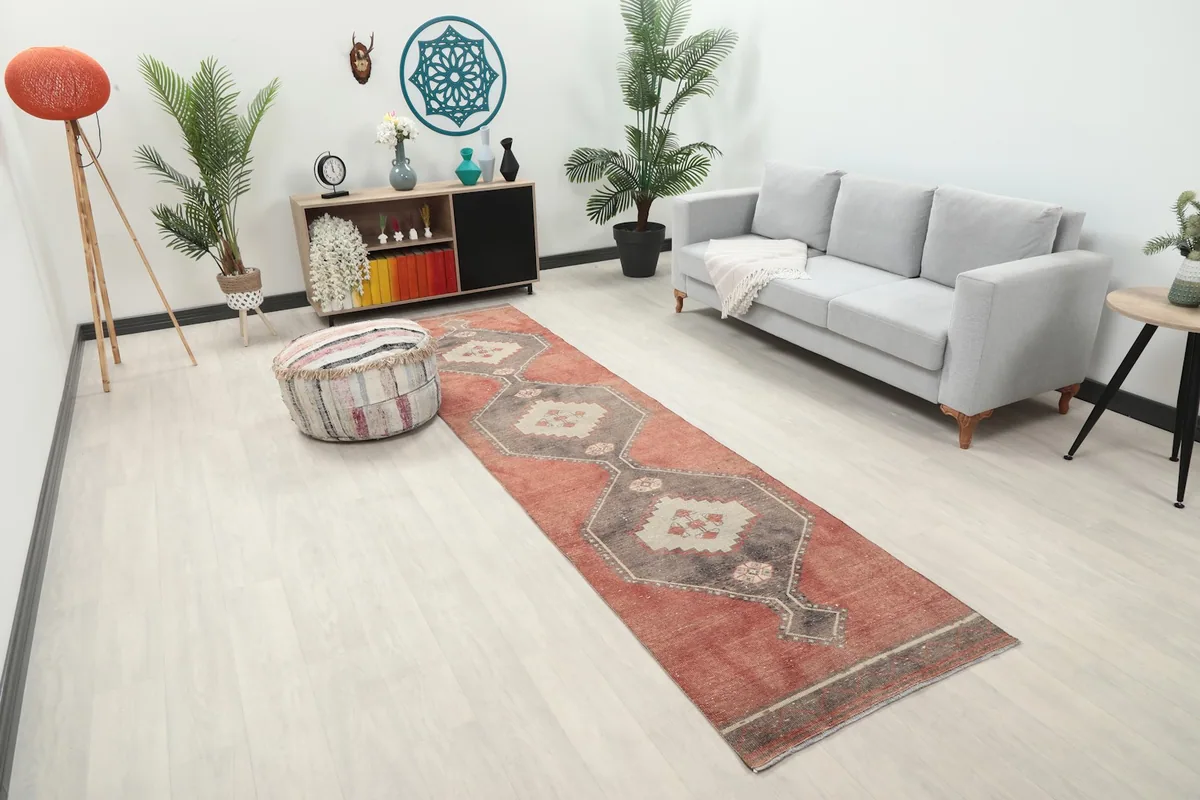 Angle view of the rust and charcoal runner rug in a living space, showing its length and pattern.