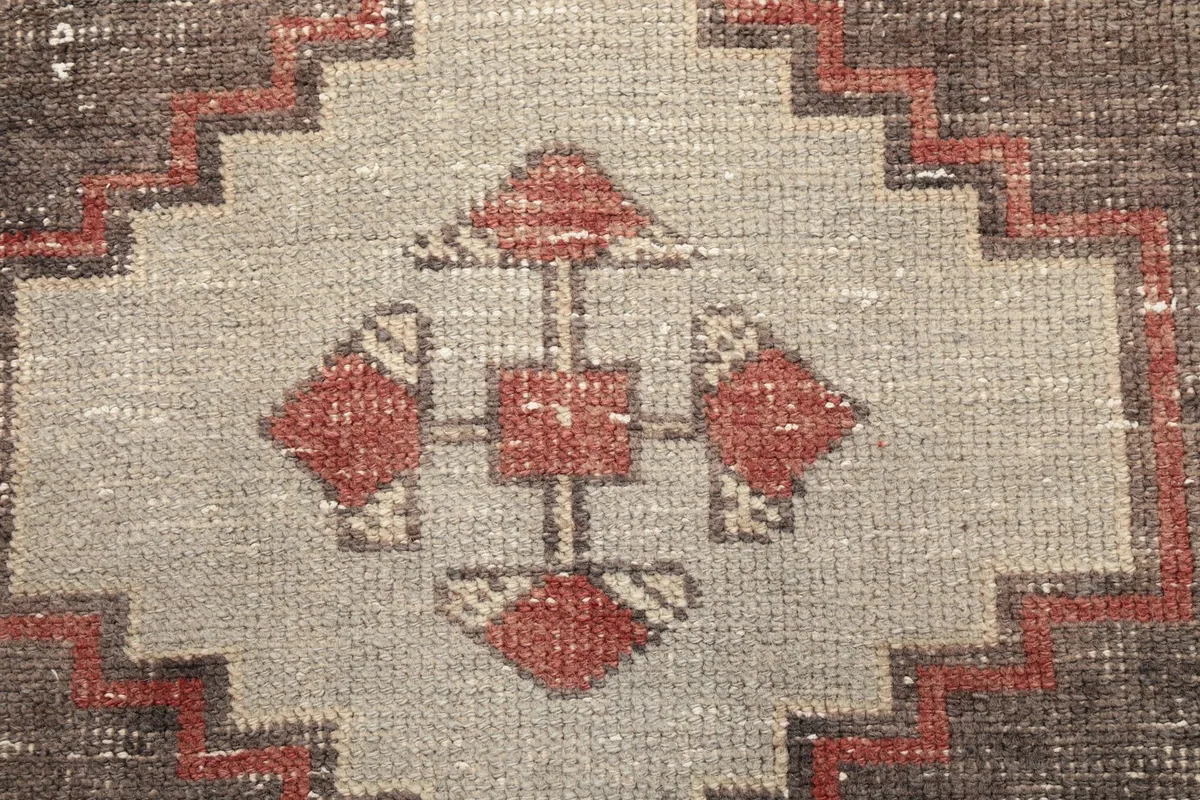 Extreme close-up of the central motif within a geometric medallion, showing knotting details and colors.