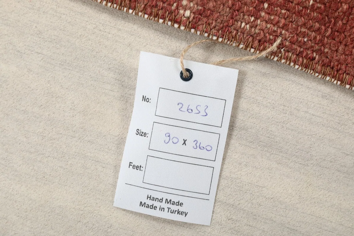 Product tag showing the rug's size in centimeters (90 x 360 cm) and confirming handmade origin from Turkey.