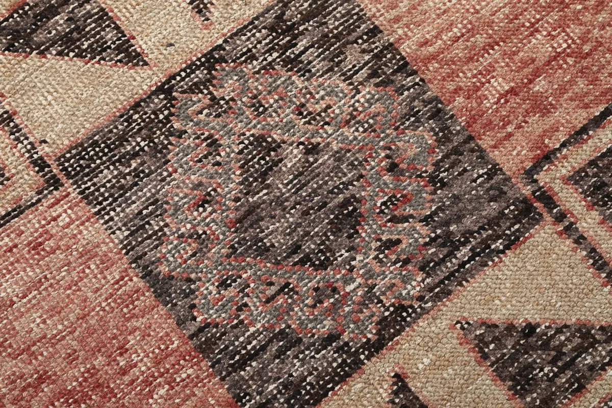 Extreme close-up of the wool pile and intricate hand-knotted details of the rug's central design