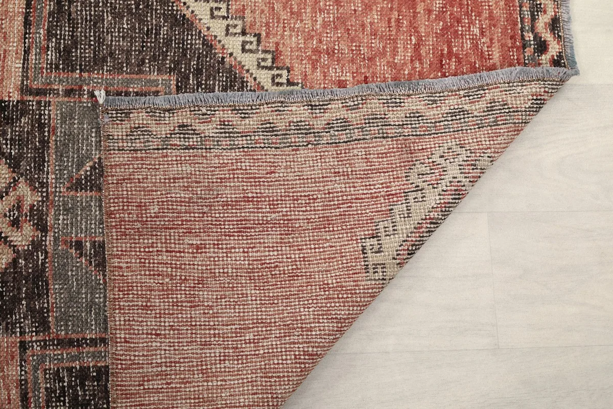 Close-up of the rug's reverse side, showing the intricate weaving of the wool pile and cotton foundation