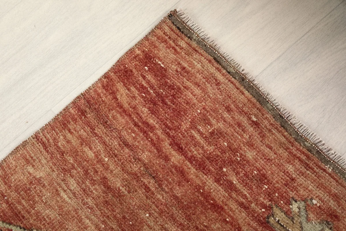 Close-up of the low wool pile and natural color variations in the rust section of the rug.