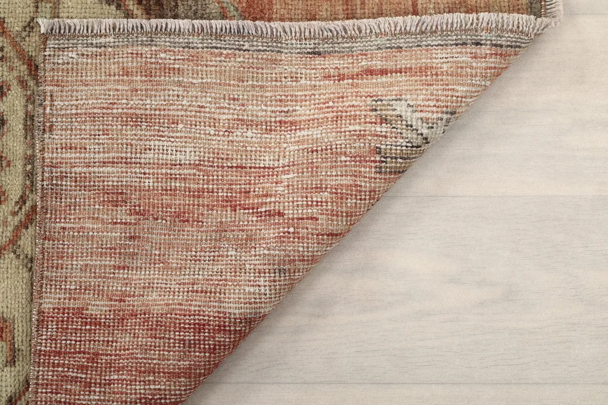 Underside corner of the rug, revealing the woven cotton foundation and hand-knotted construction.