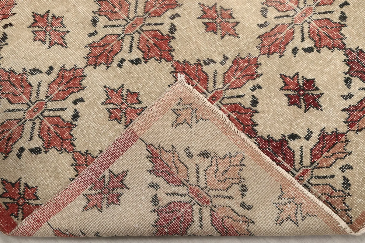 Folded corner of the rug revealing the cotton foundation and reverse side of the knots
