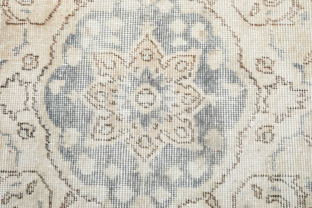 Close-up view of the central medallion, highlighting the intricate faded floral and geometric motifs