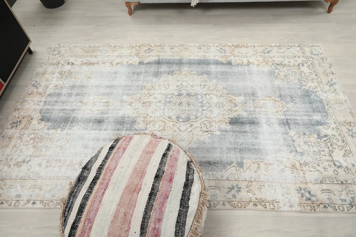 Overhead shot of the full rug, emphasizing its faded appearance and overall design in a room setting
