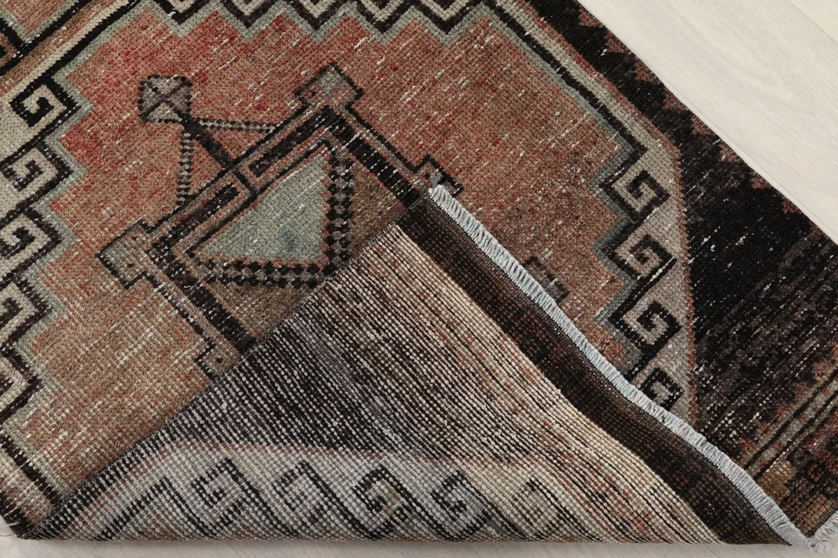 Folded corner of the runner revealing the wool pile and cotton foundation