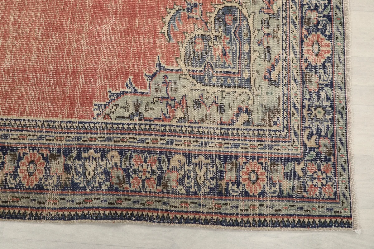 Detail of the navy and cream border with floral and geometric patterns on the vintage Anatolian rug