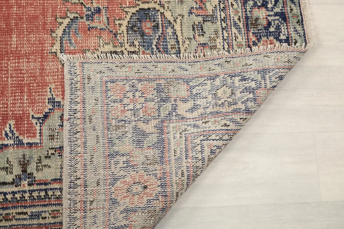 View of the rug's reverse side and folded corner, showing the tight knotting and foundation