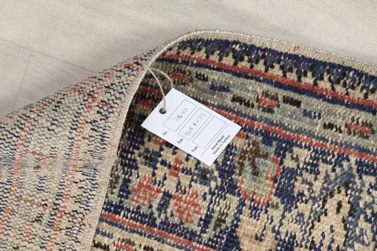 Close-up of the rug's back with a product tag, displaying size information and the hand-knotted construction