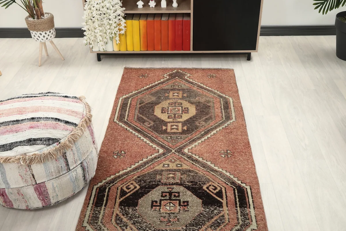 View of the rug in a room from a higher angle, highlighting its long runner shape and pattern.