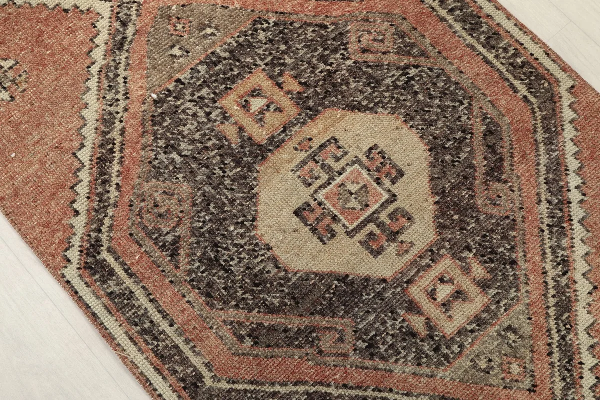 Close-up of a central charcoal diamond motif with beige and rust accents.