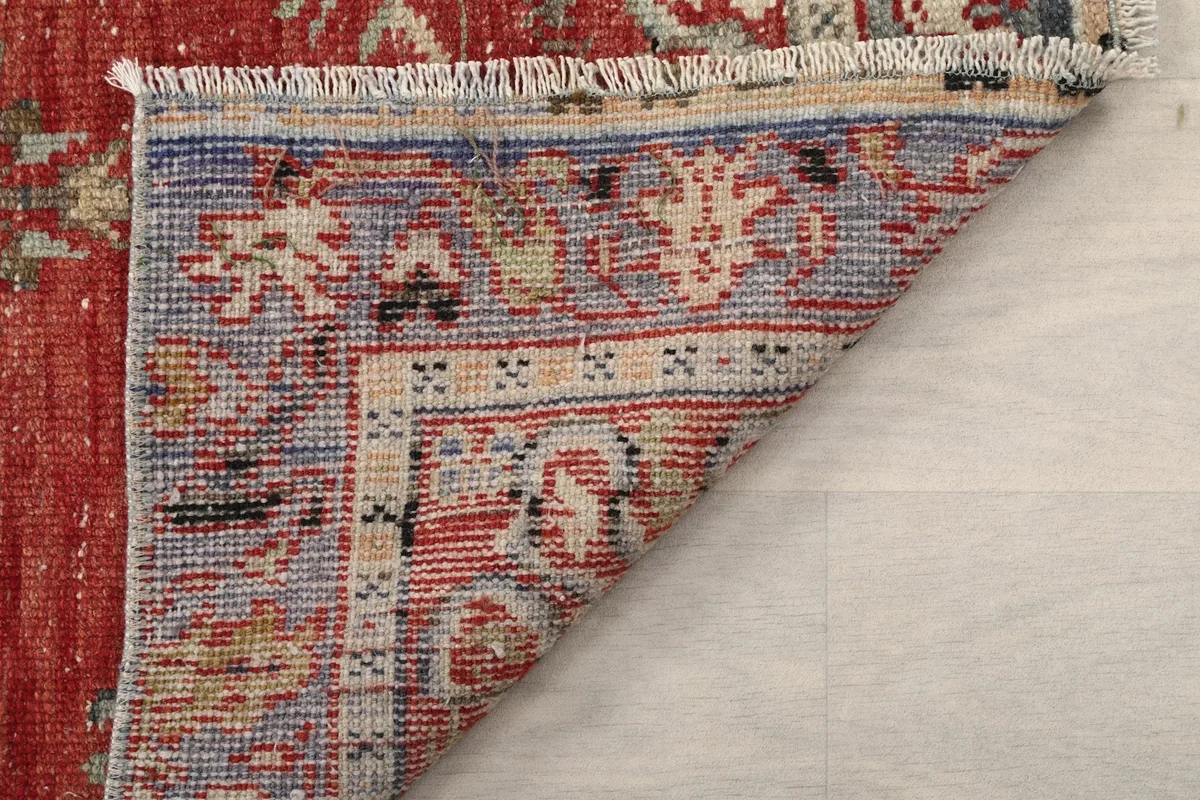 Close-up of the folded rug corner, showing the tightly woven cotton foundation and fringe