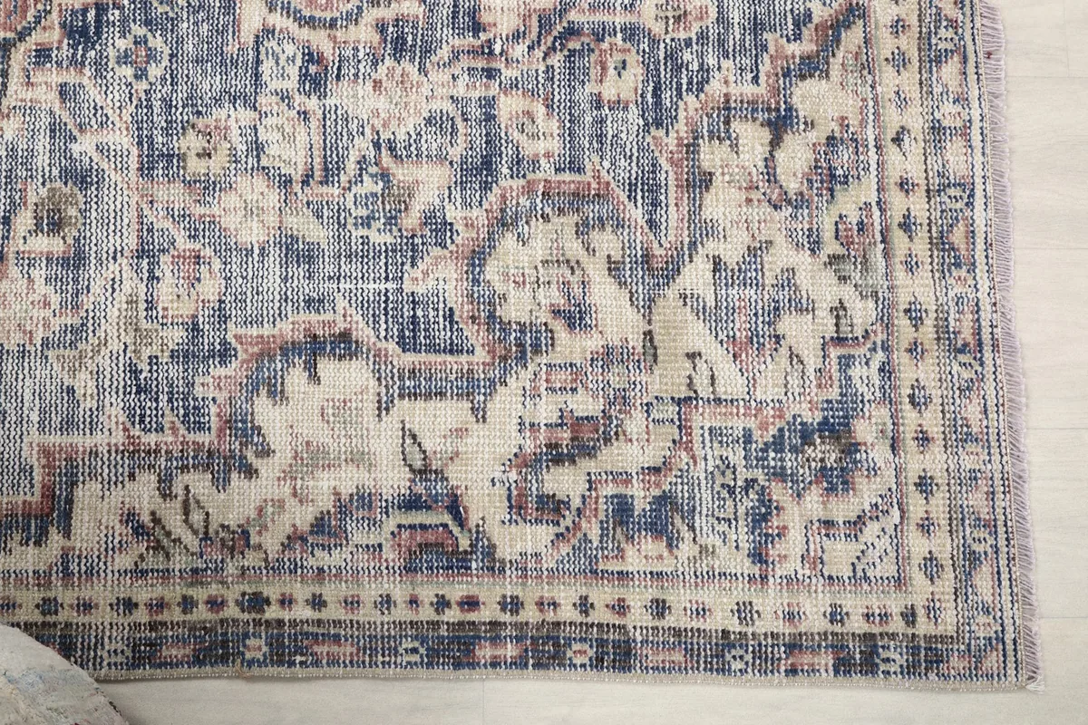 Detailed view of the rug's corner showcasing the beige border and indigo patterns