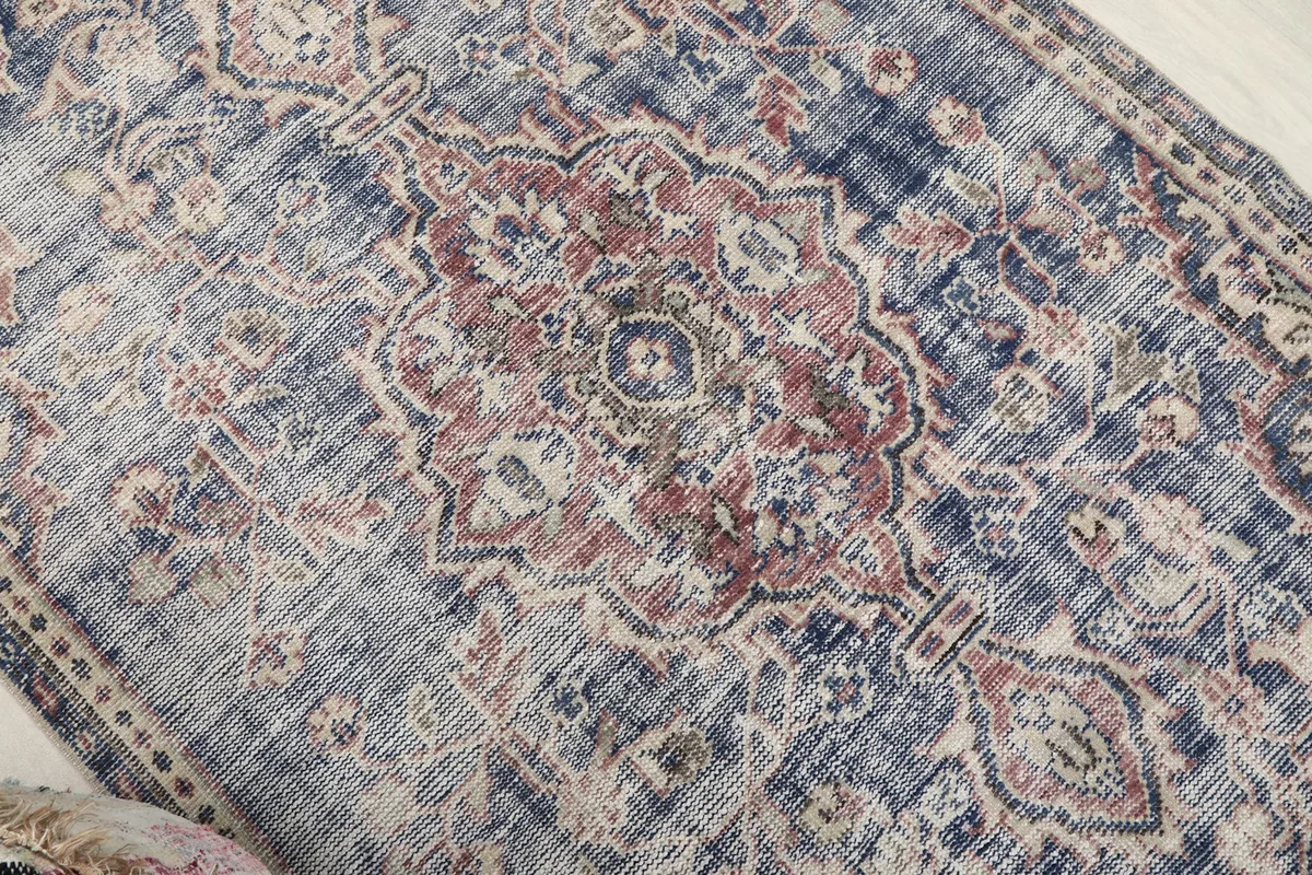 Close-up of the central rose and indigo medallion motif with distressed areas