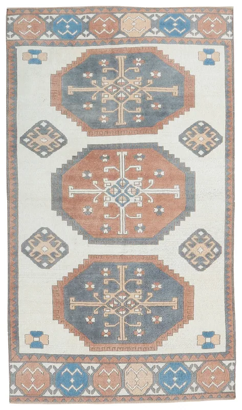 Full top view of a 4'1" x 7'7" vintage Anatolian rug with cream, rust, and blue geometric patterns