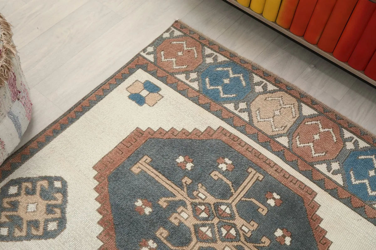Angled close-up of the rug's top border and a blue geometric medallion
