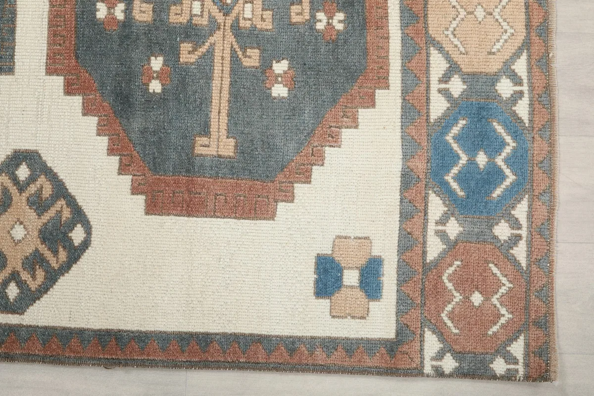 Detailed view of the corner border and a geometric medallion on the cream field