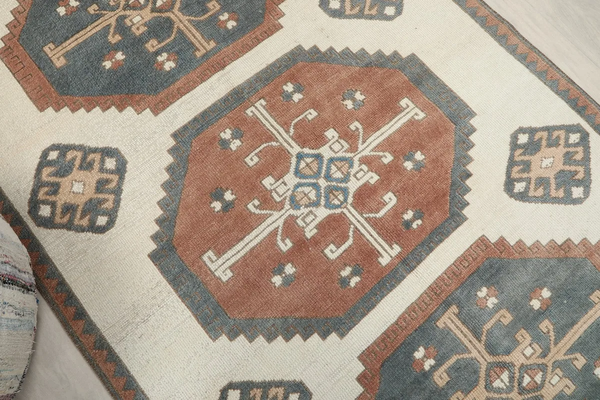 Close-up of the central rust medallion with intricate cream and blue geometric motifs