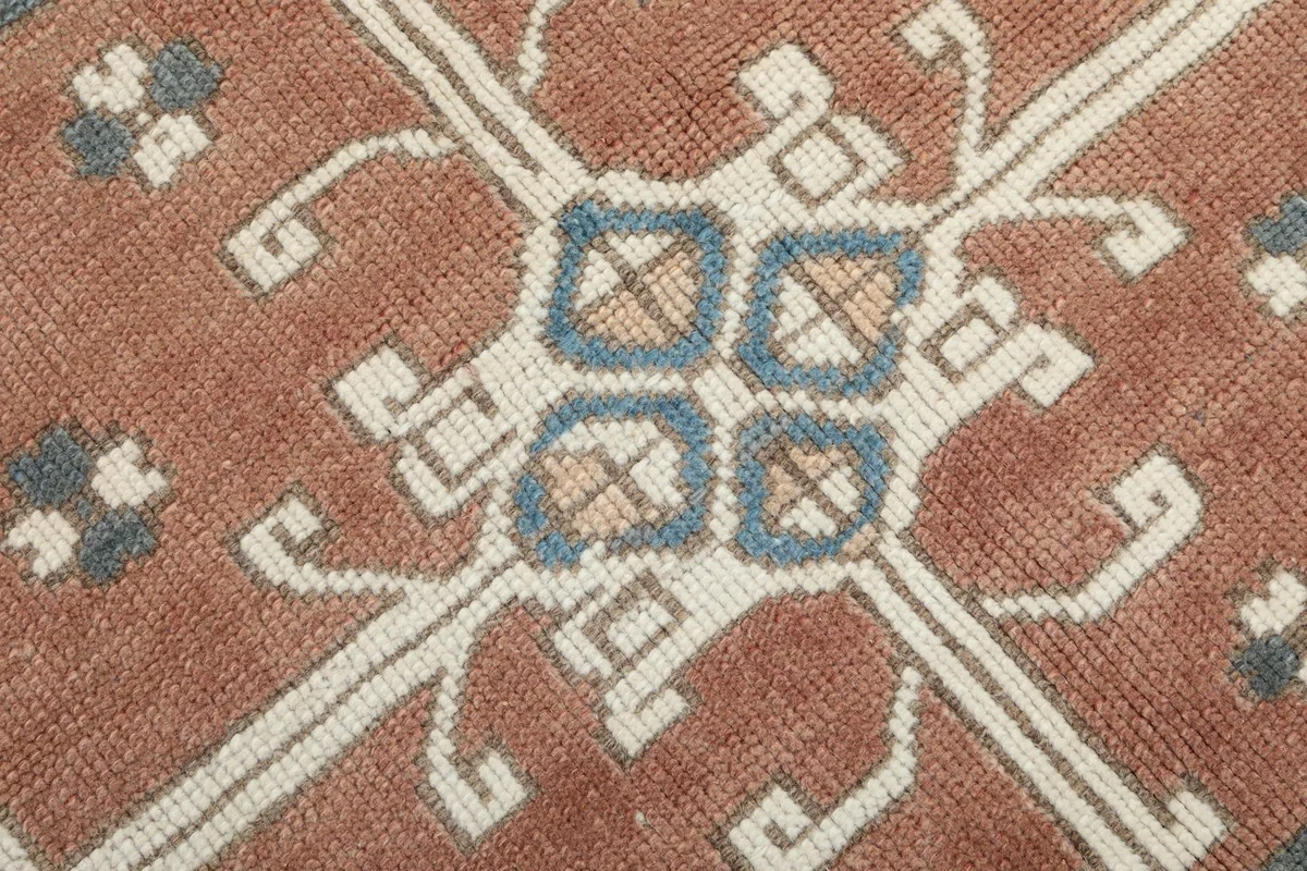 Macro detail showing the low pile texture and colors of the rust and blue motifs