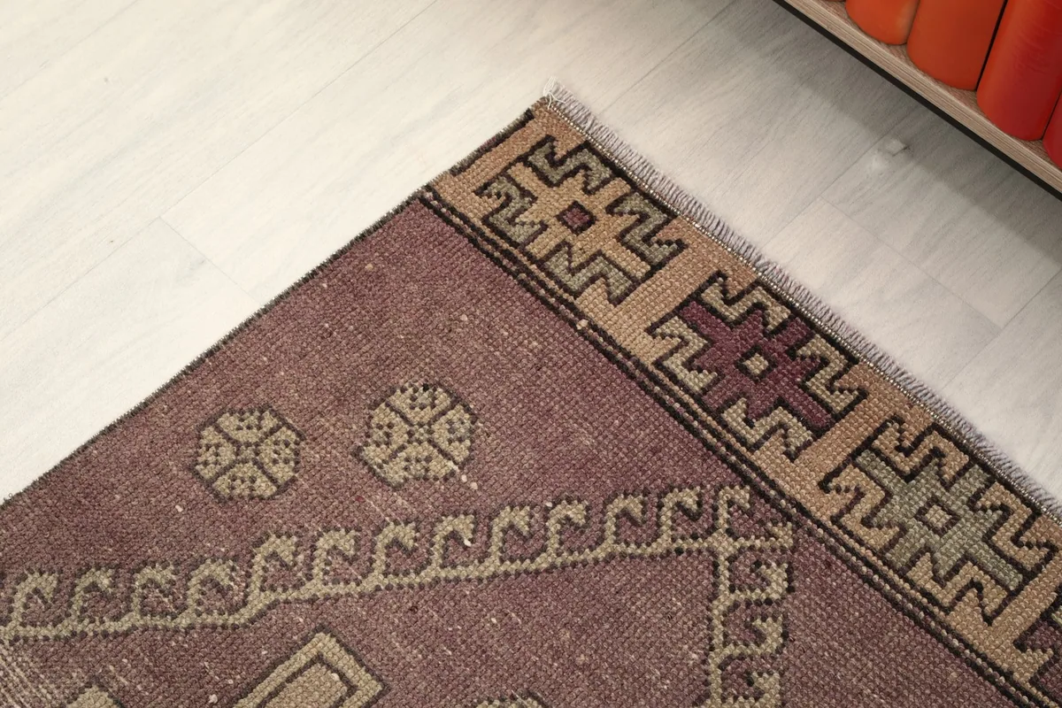 Corner detail of the runner, focusing on the border design and the varying shades of rose and beige.