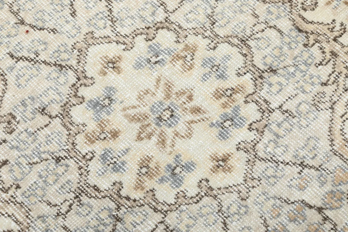 Macro detail of the hand-knotted wool pile, showing individual knots and color variations in the pattern