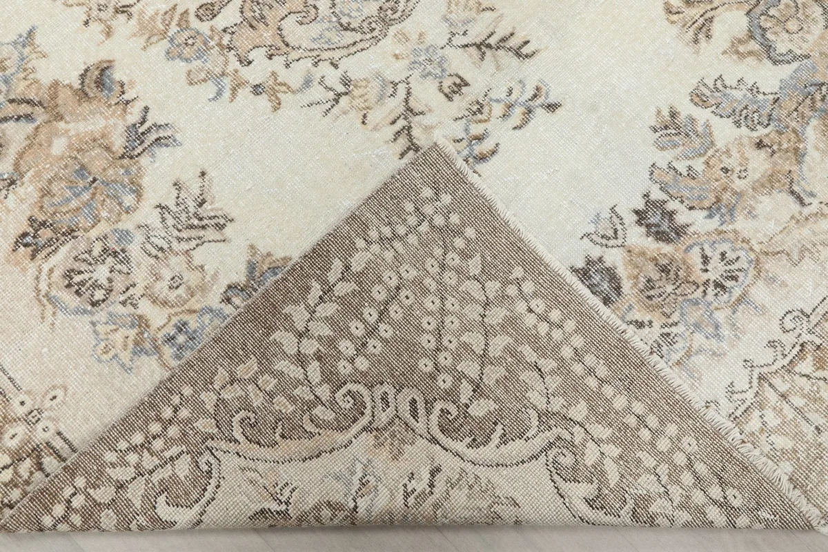 Folded corner revealing the back of the hand-knotted rug, showing the cotton foundation
