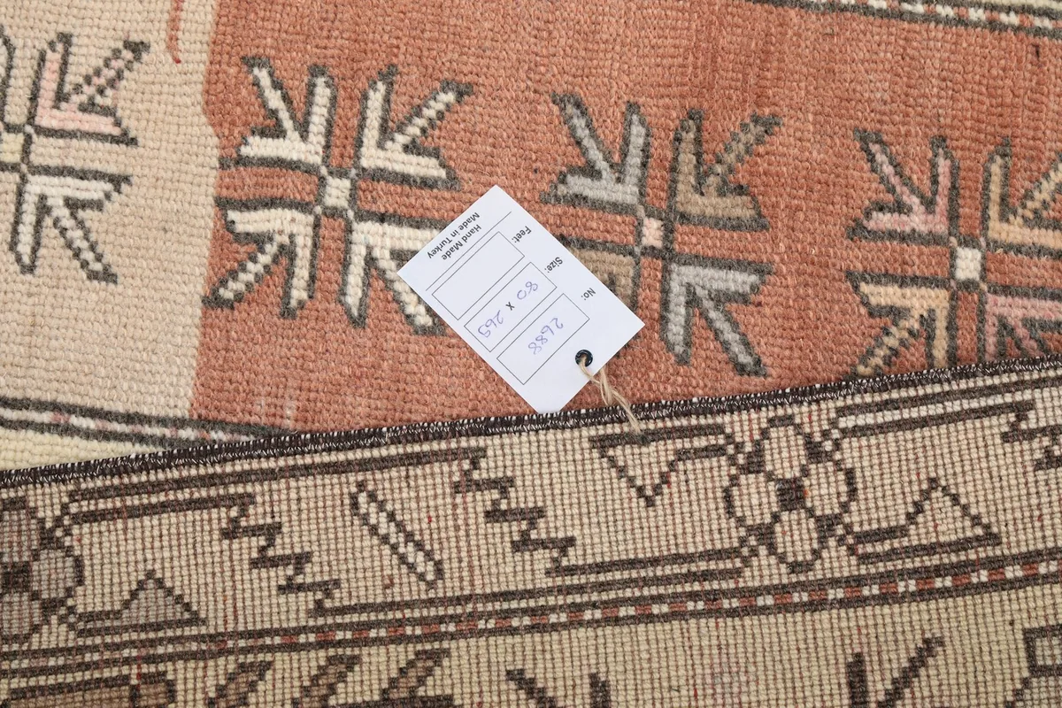 Close-up of the rug's pattern with a size tag, indicating its hand-knotted wool texture