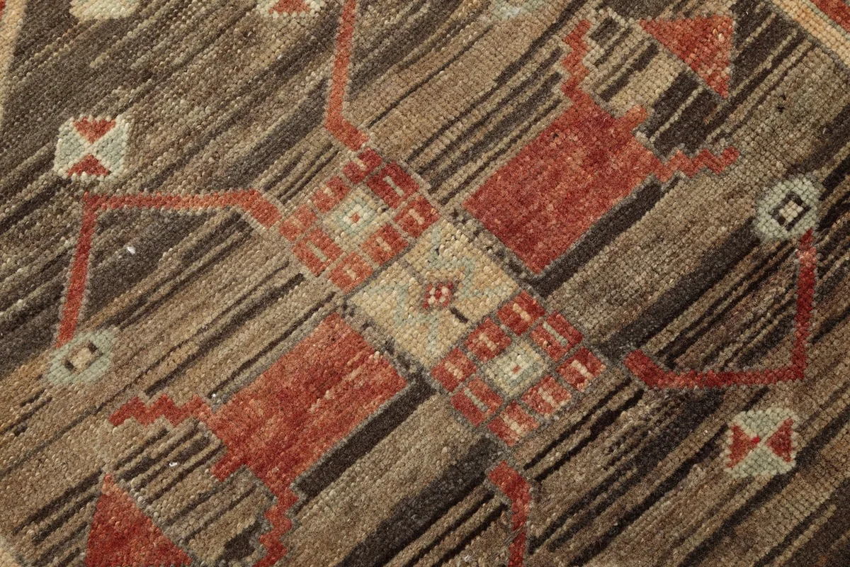 Extreme close-up of the hand-knotted wool pile and tribal design elements