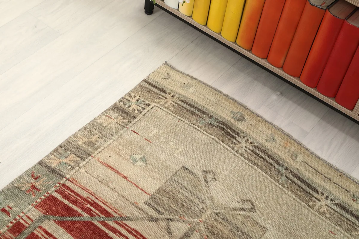 Close-up of the end of the runner rug, showing the tan border and subtle motifs