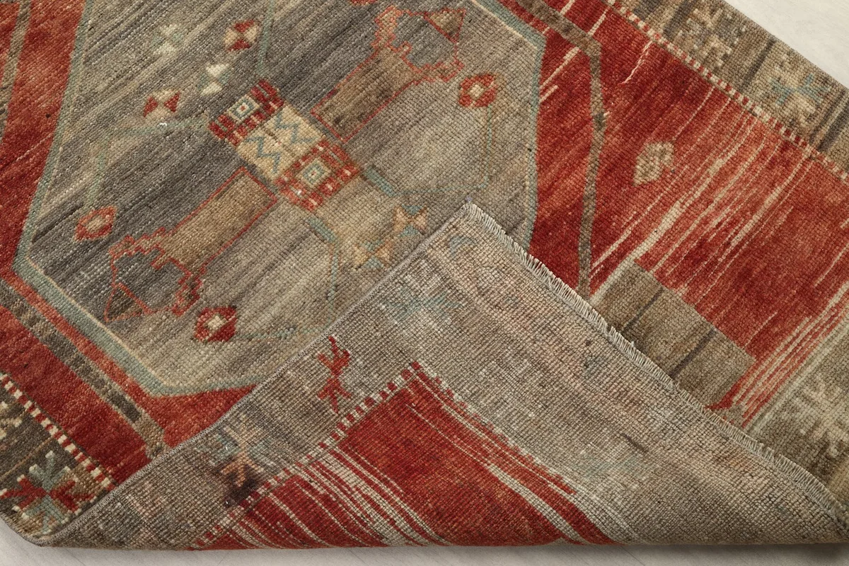 Corner of the runner rug folded back, revealing the wool pile and cotton foundation