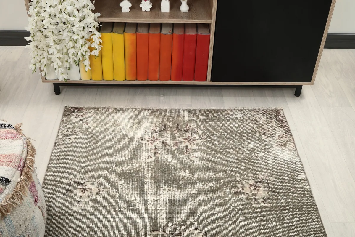 View of the gray rug from above, showcasing its full pattern and distressed character in a room setting.