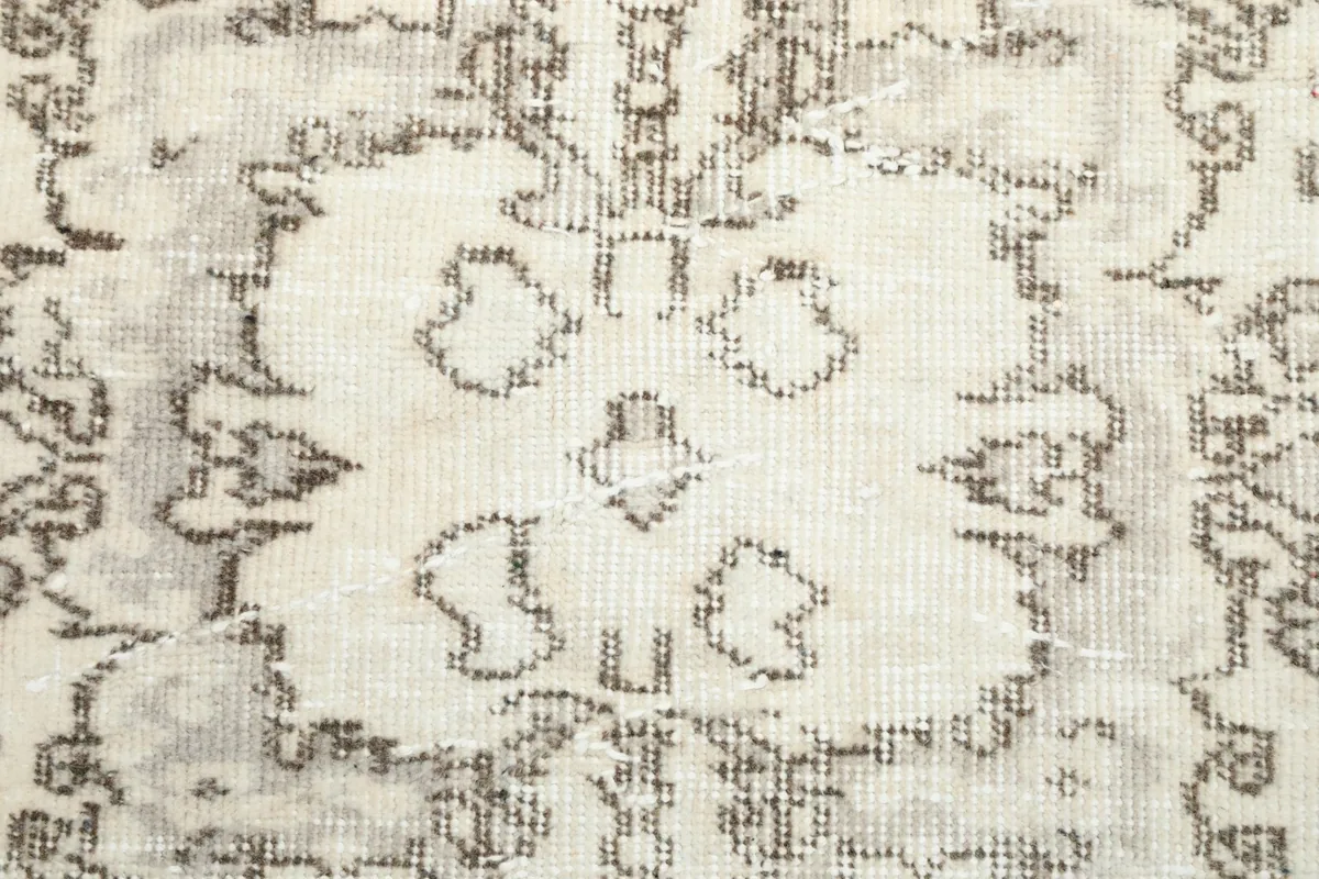 Macro detail of the central medallion, revealing the hand-knotted wool pile and subtle wear.