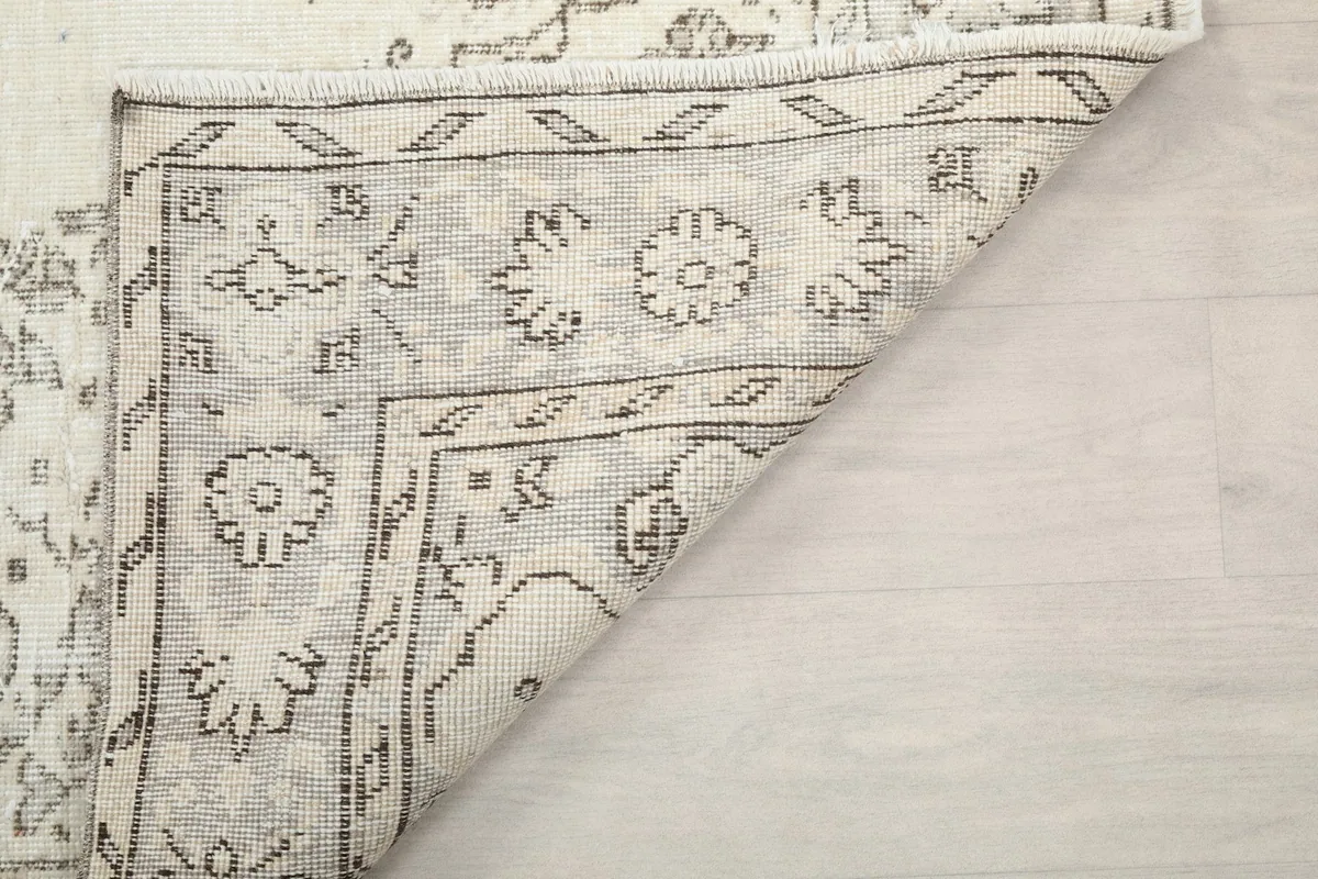 Close-up of the rug's underside and fringe, illustrating the quality of the hand-knotting and the cotton foundation.