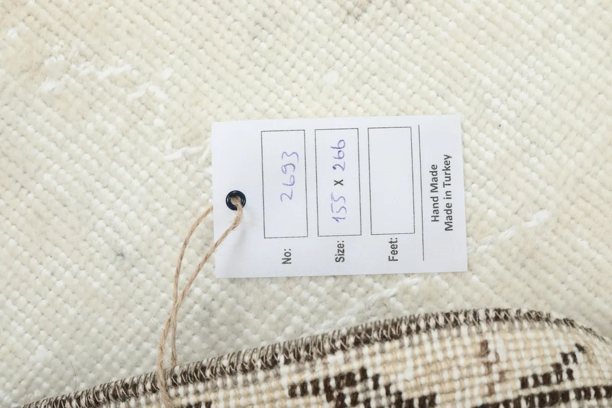 Tag showing the rug's dimensions (155 x 266 cm) and indicating it is hand-made in Turkey.