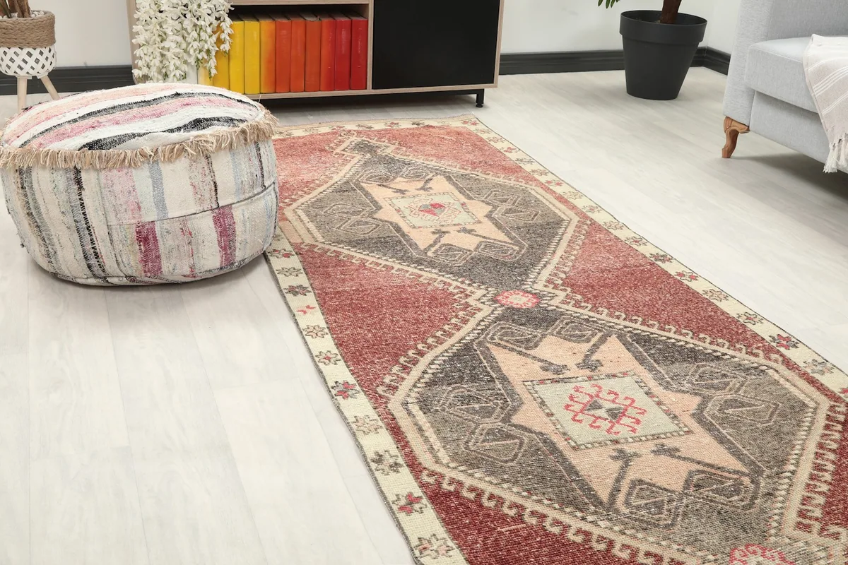 Close-up view of one end of the runner in a room, next to a decorative ottoman.