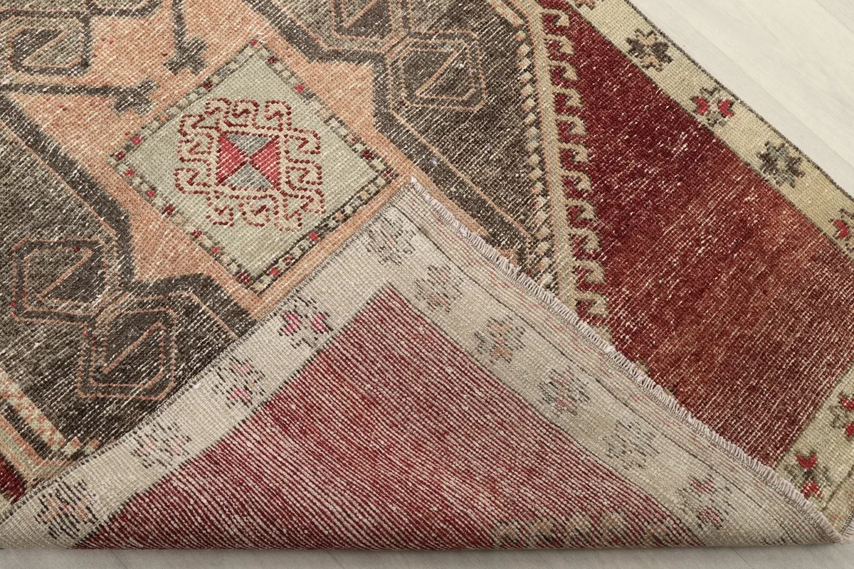 Corner of the runner folded to show the hand-knotted wool pile and cotton foundation.