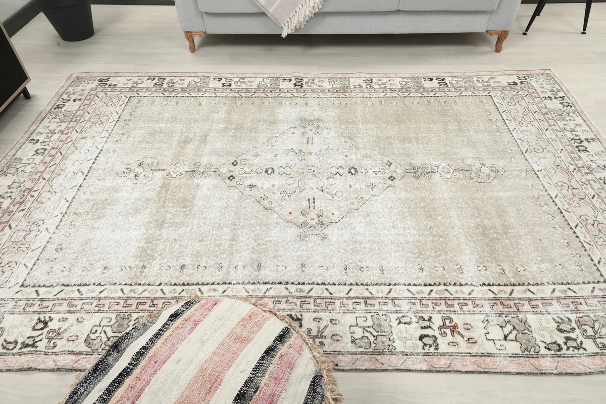View of the rug in a room, emphasizing its size and the subtle patina on the gray field.