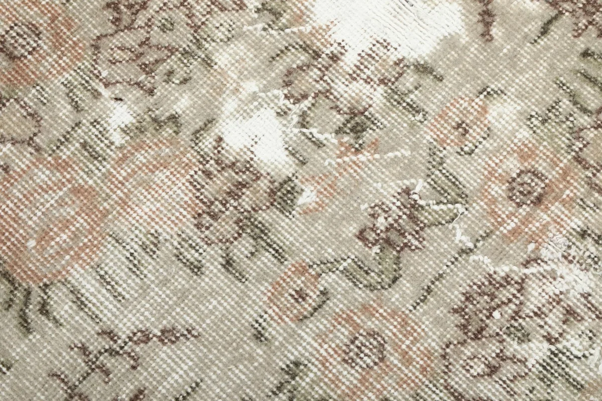 Close-up showing the low pile texture and intricate hand-knotted details of the wool rug