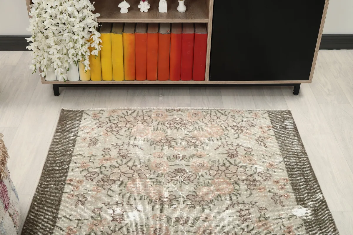 Overhead view showcasing the full floral design and distressed patina of the vintage rug